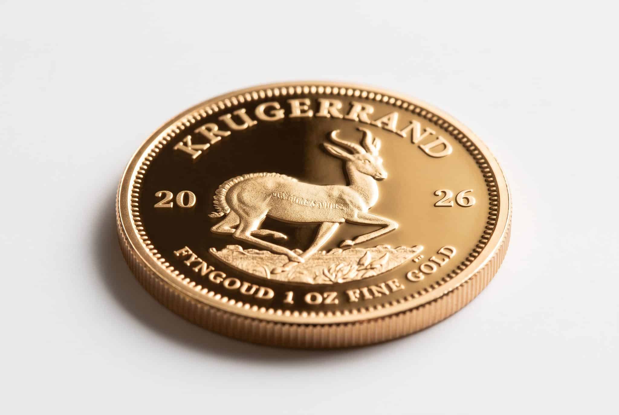 Angled close-up of a 2026 Krugerrand 1 oz fine gold coin showing the leaping springbok, the "Krugerrand" and "Fyngoud 1 oz Fine Gold" inscriptions and the reeded edge, on a white background.